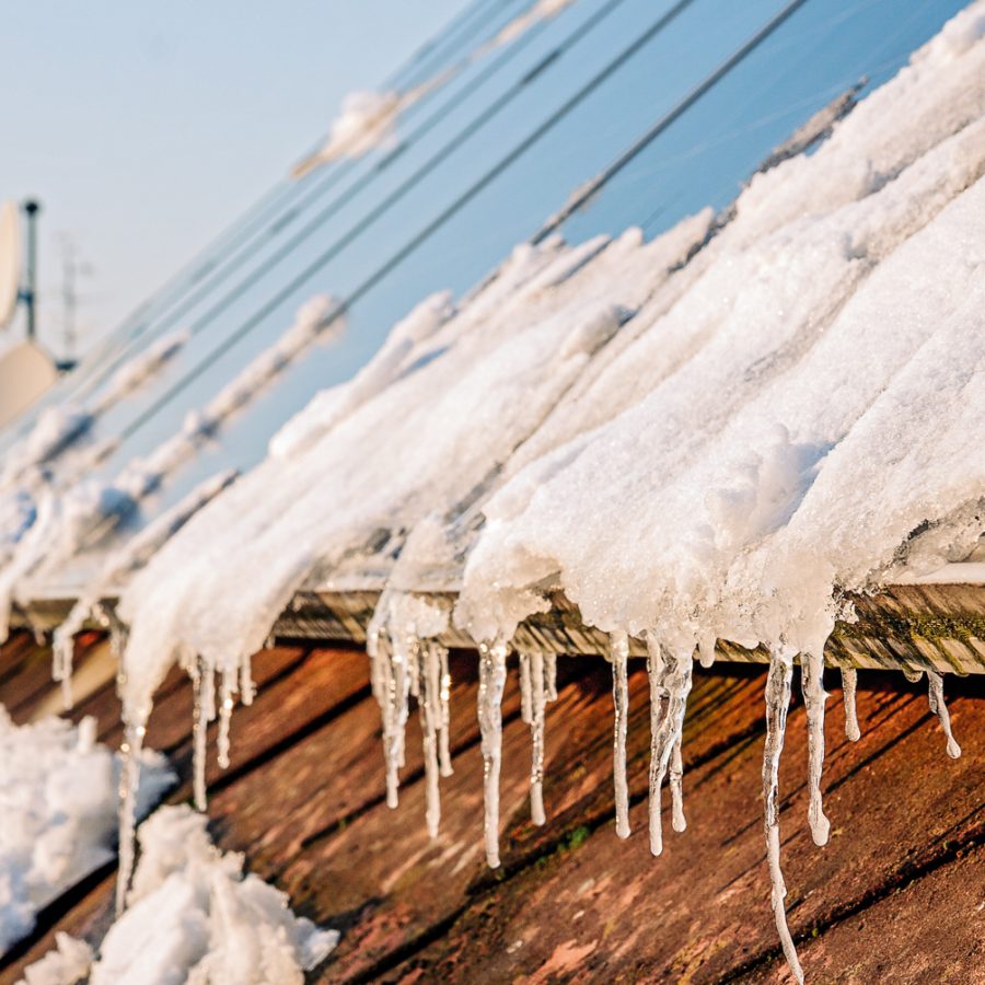 Solcellepanel dekket av snø som tiner